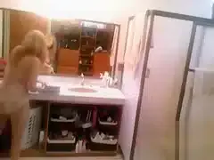 Busty blonde brushes her hair and takes a shower