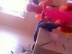 Chubby old woman in her bathroom urinates and washes