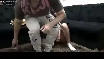 Hot young girl having sex with a well-endowed man in the living room while her husband is there.